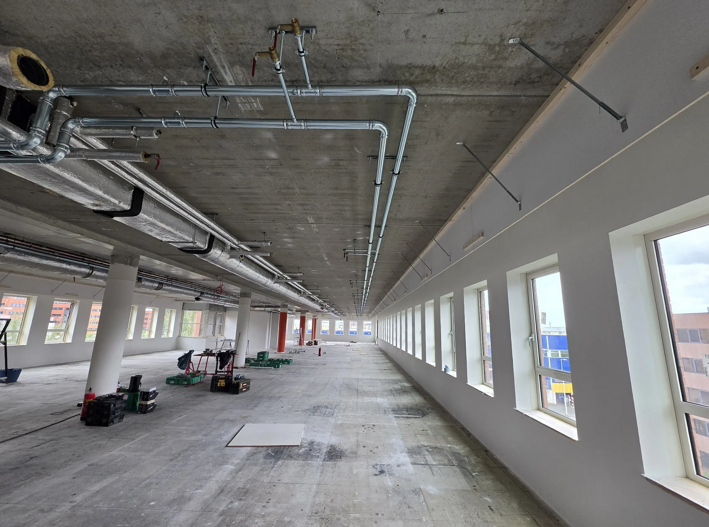 Technical installation with pipework along the ceiling of a commercial building under construction