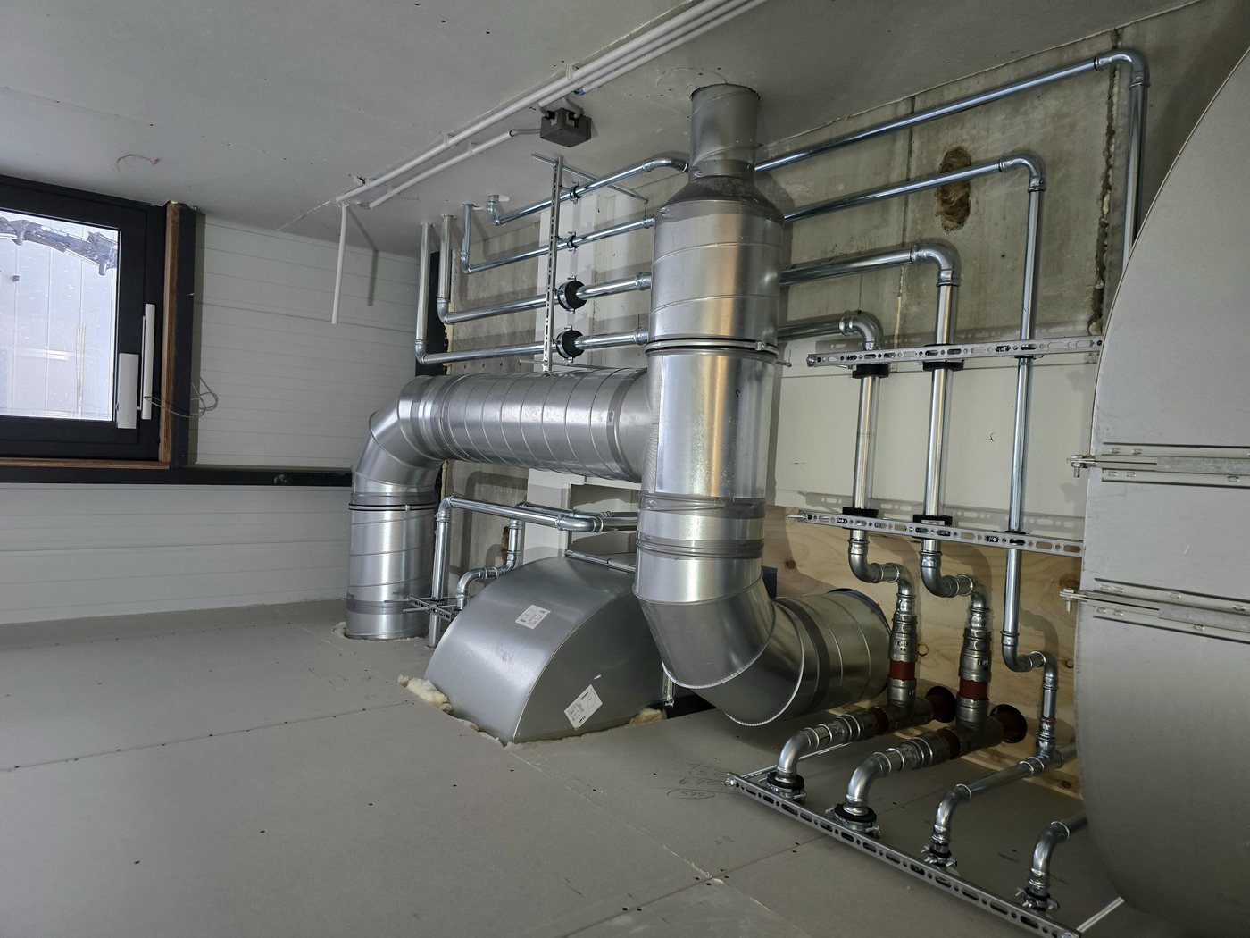Detail van leidingwerk en kanalen in een technische schacht bij de kliniek