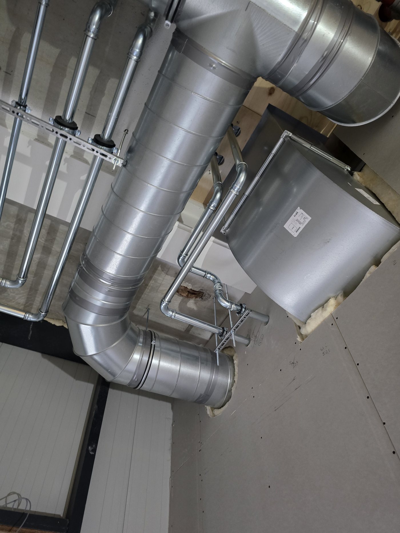 Installatie van een ventilatie-unit met kanalen tegen het plafond