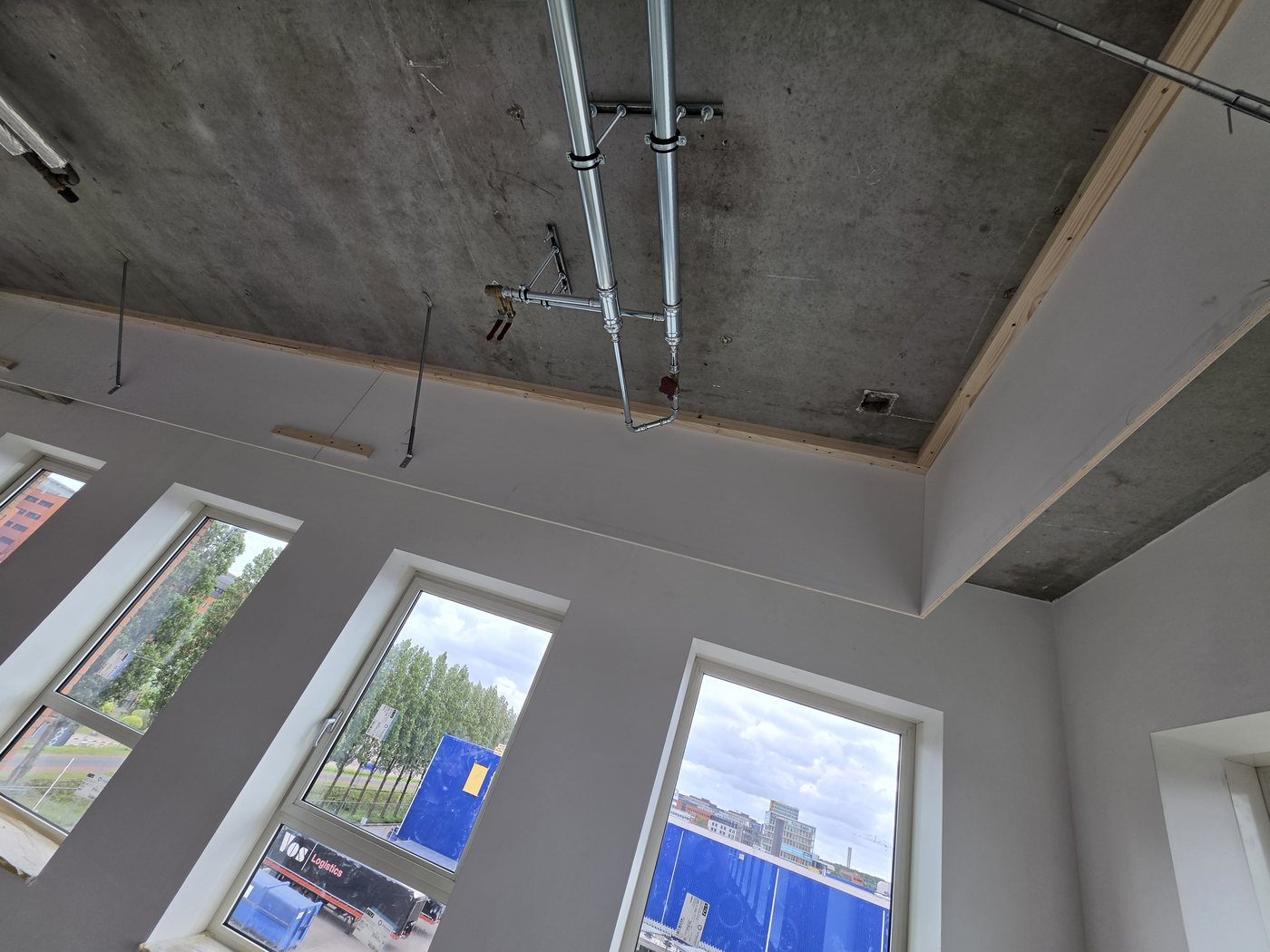 Sprinklerleidingen tegen het betonplafond met uitzicht op de skyline