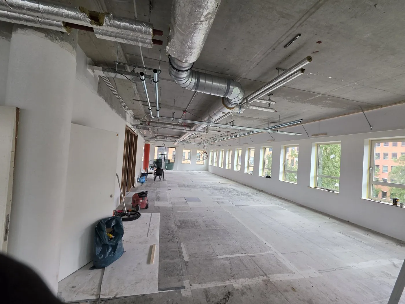 Installation work on the ceiling, with a row of windows in the background