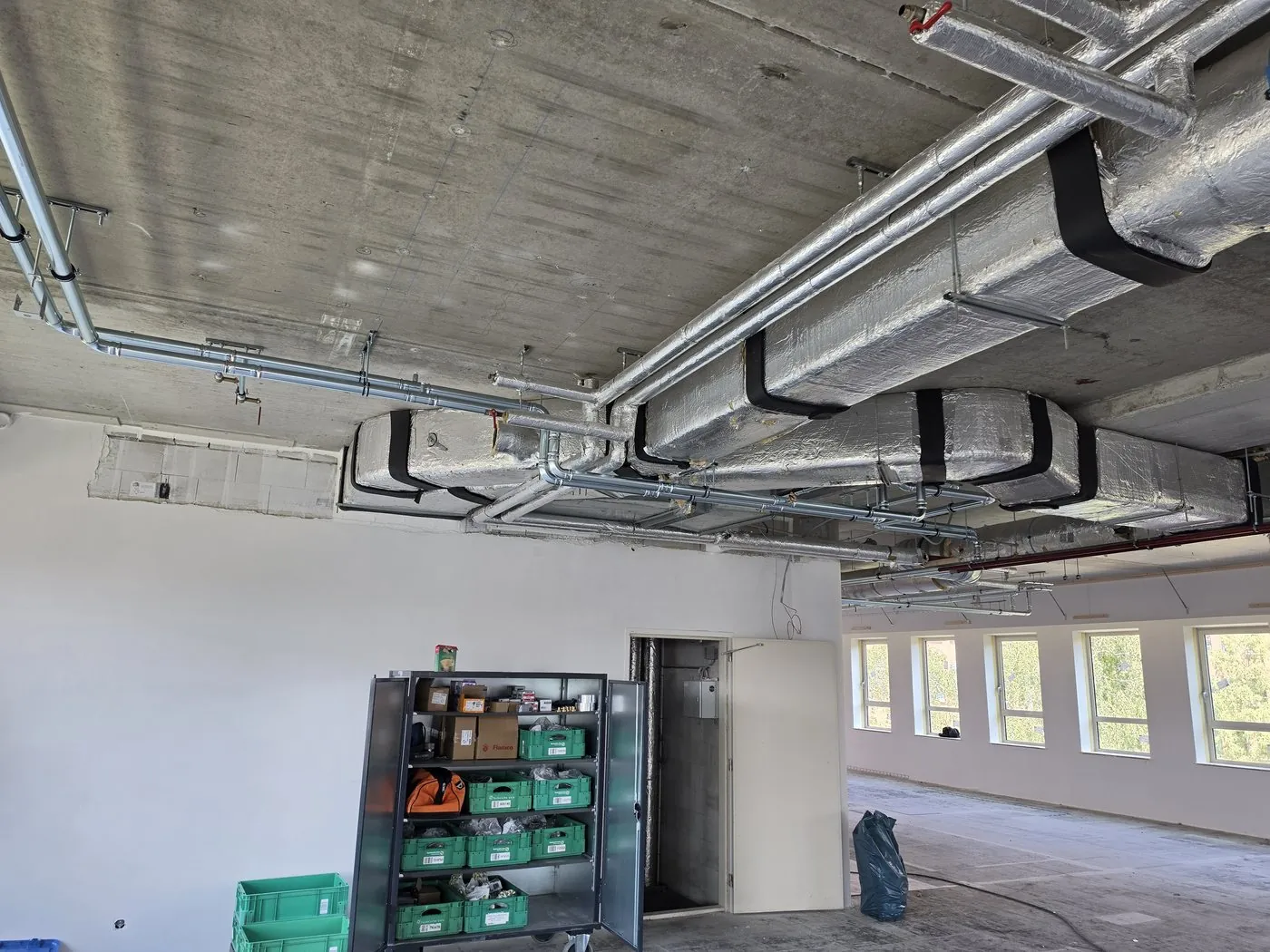 Office floor under construction, with a row of windows along the facade