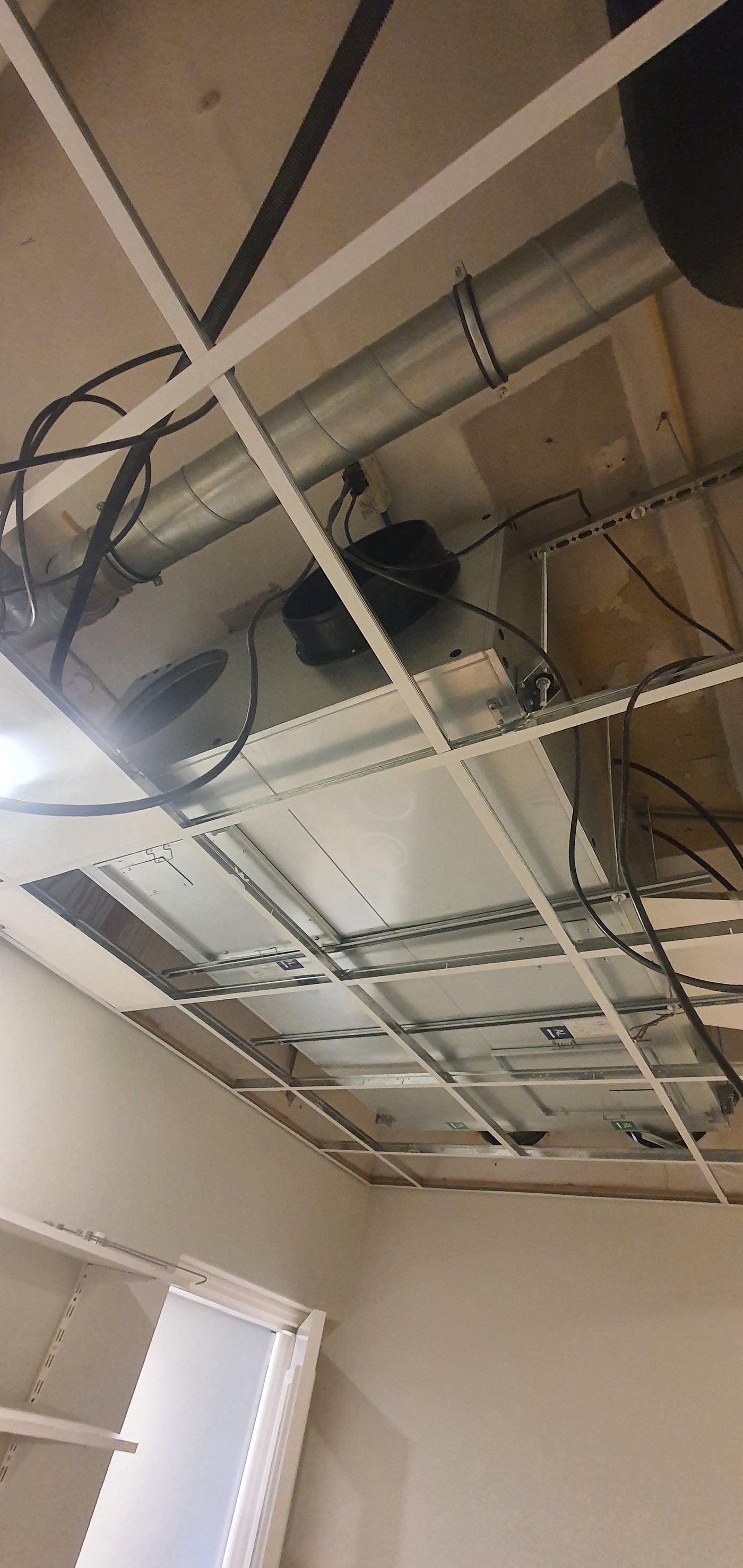 Afgewerkt systeemplafond met ventilatierooster bij de basisschool