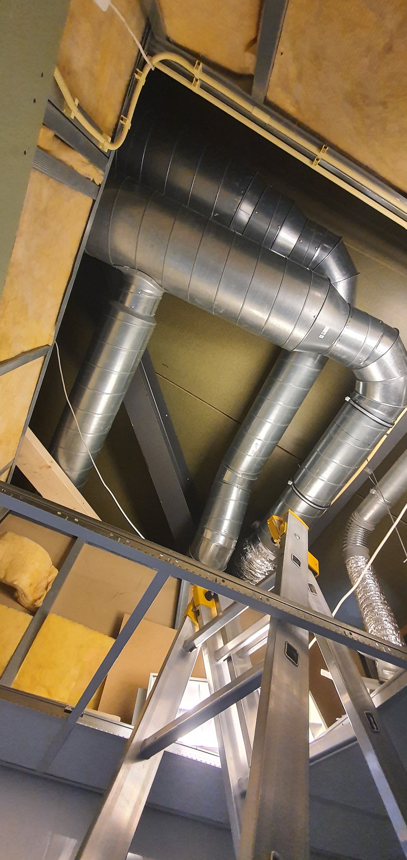 Montage van kanalen in de kapconstructie, met ladder