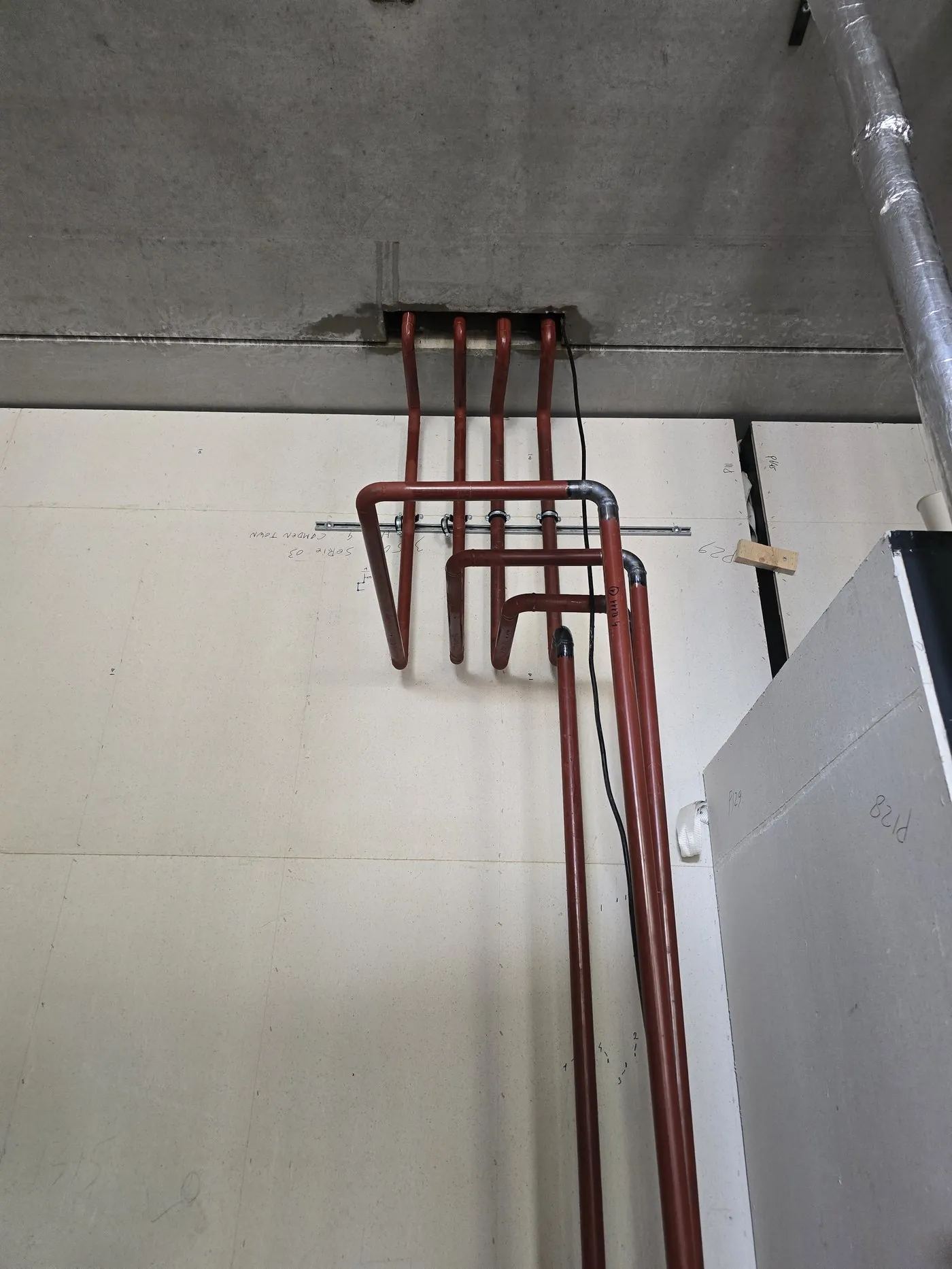 Red pipes on the ceiling, installed from a ladder