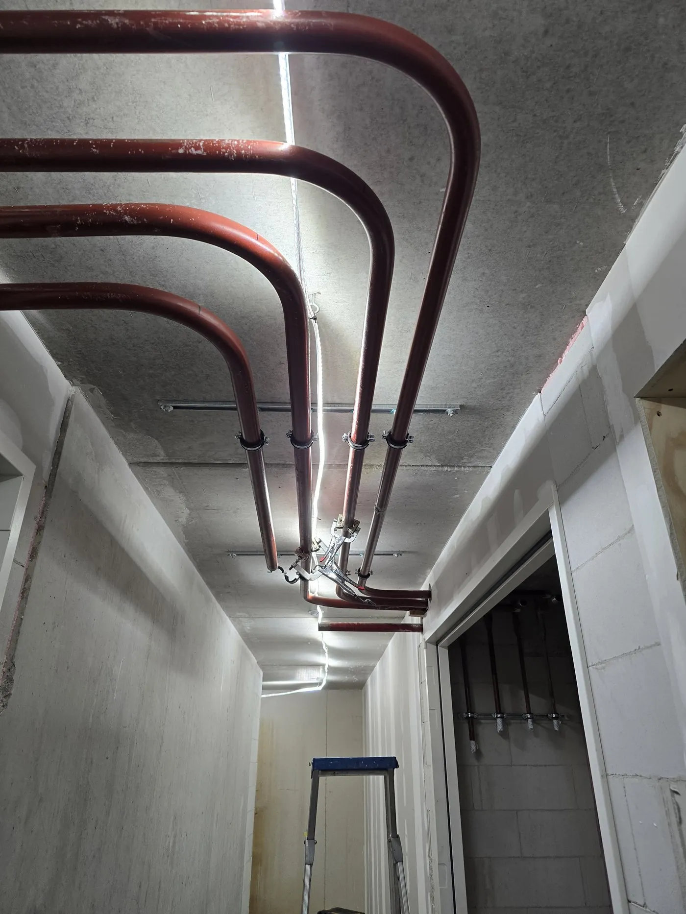 Red pipes on the ceiling of a long corridor
