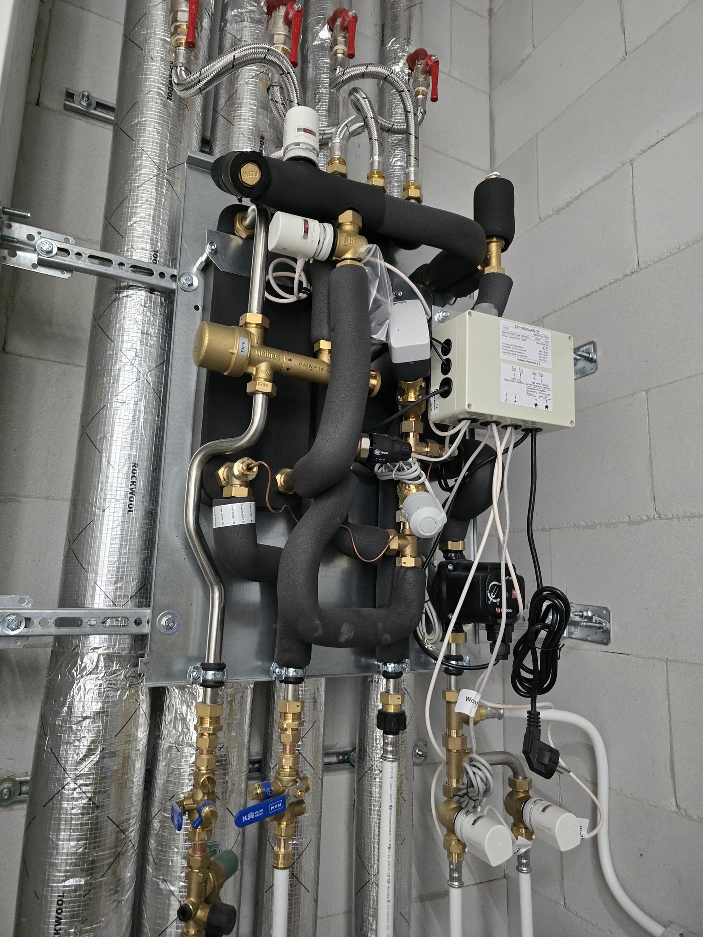 Manifold met afsluiters en pomp in een technische ruimte