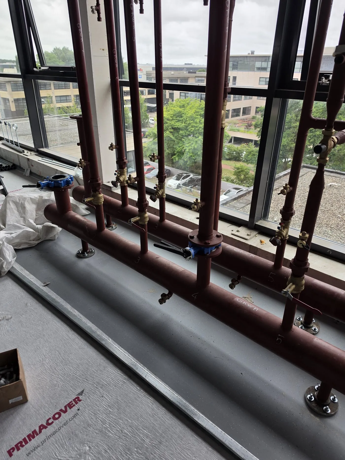 Vertical pipes against a window wall