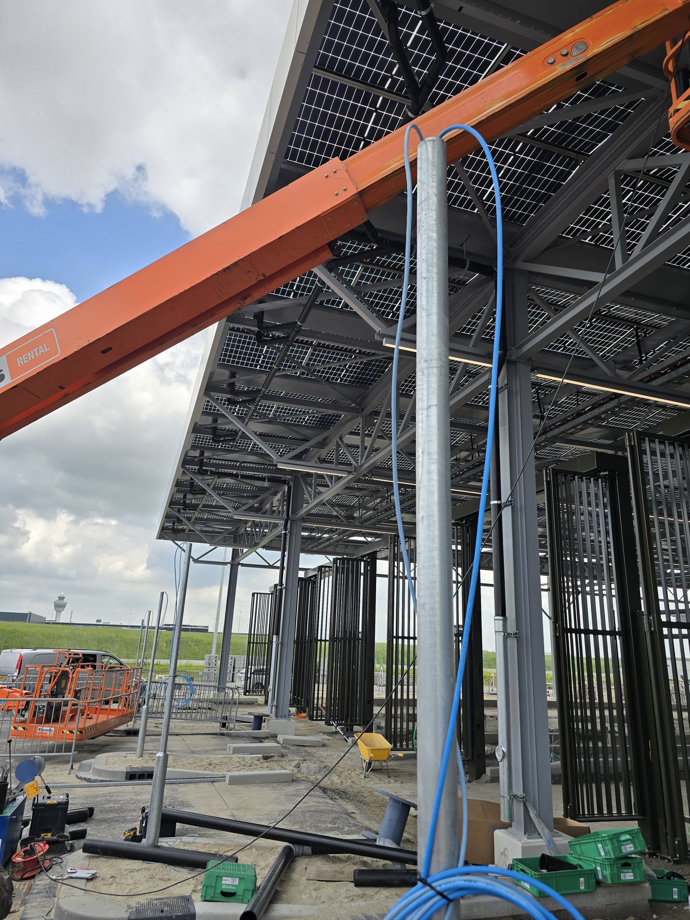 Hoogwerker aan het werk onder de zonnecarport bij Schiphol