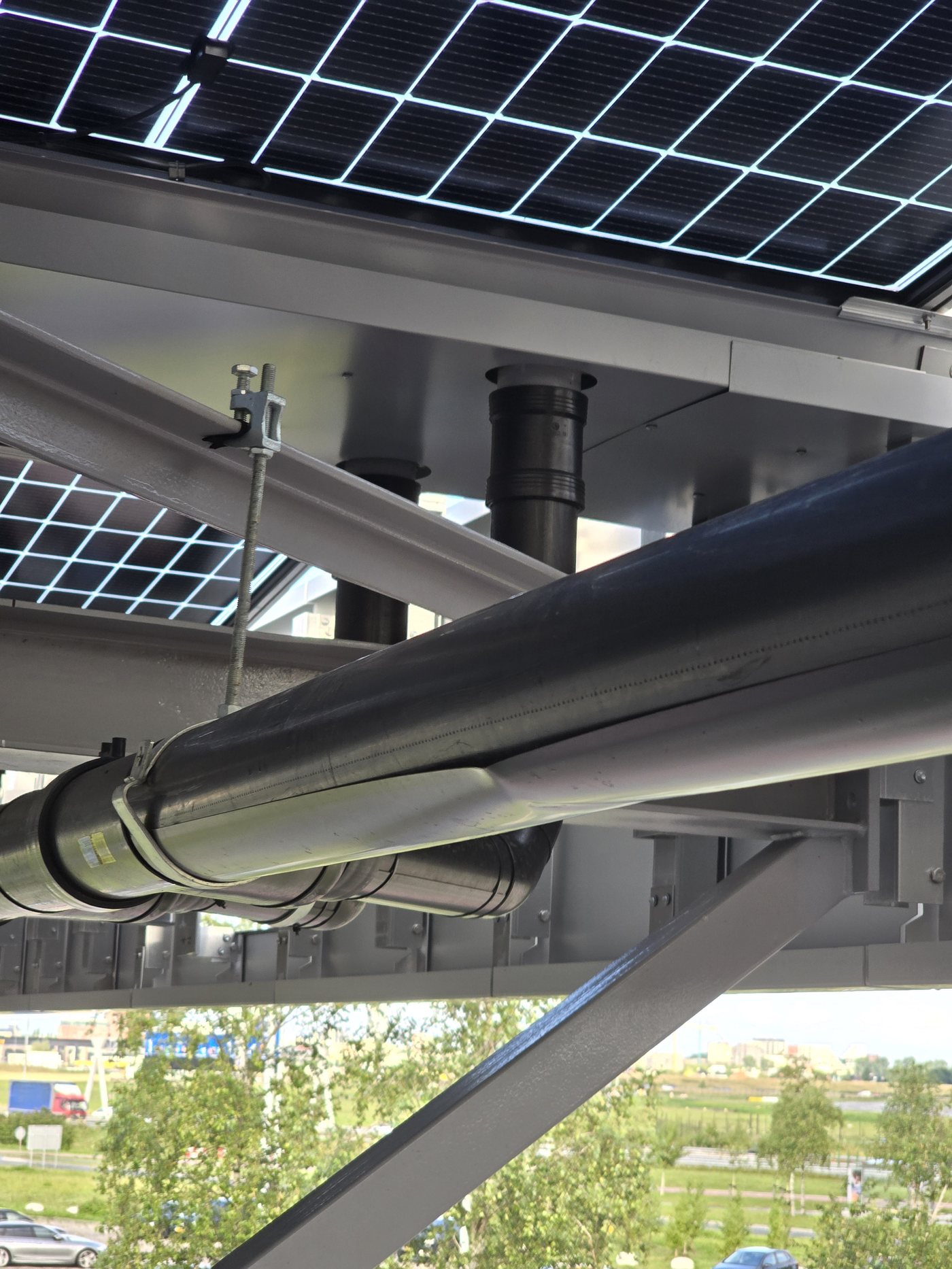 Afgewerkte leiding bevestigd aan de staalconstructie onder de zonnepanelen