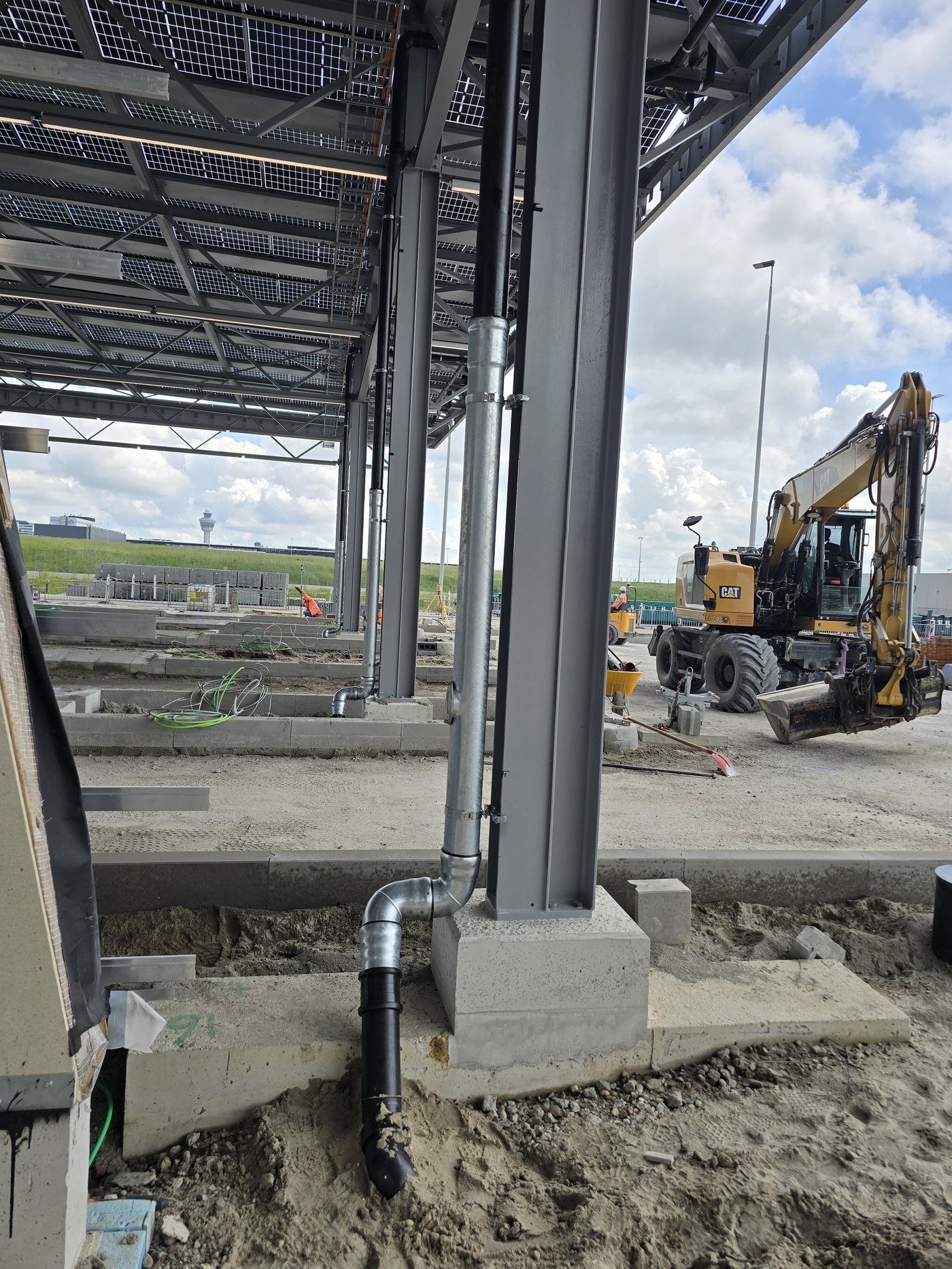Graafmachine legt een leiding aan onder de zonnecarport