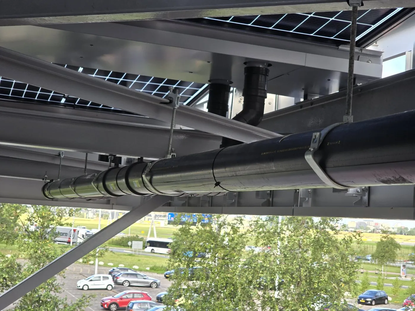Installed pipe along the steel structure, with the road in the background