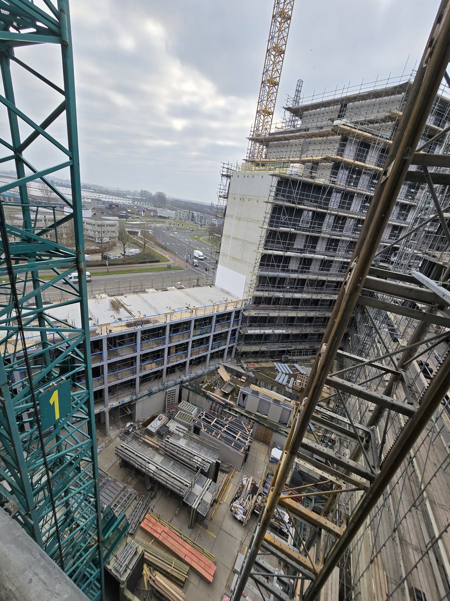 Bouwplaats in Amsterdam met kraan en steigerwerk rond het kantoorgebouw in aanbouw